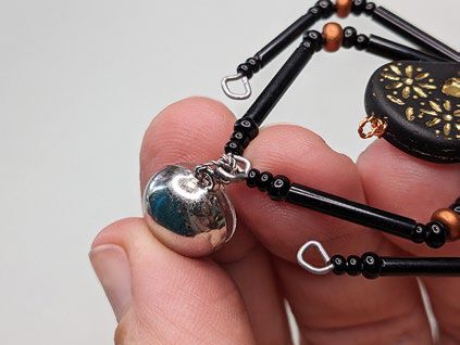 Earring finding is attached to both back legs, which are wired together.